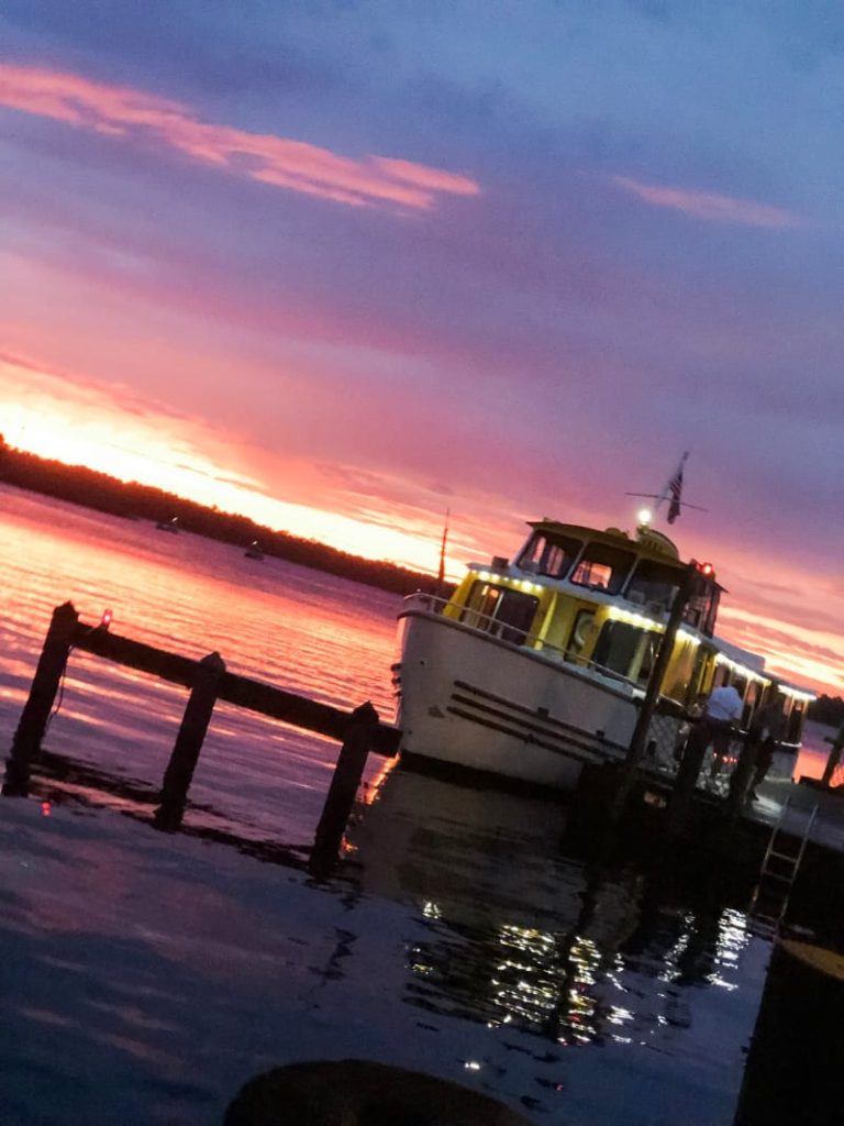 Boat with beautiful sun set reflecting off the lake in the background. 