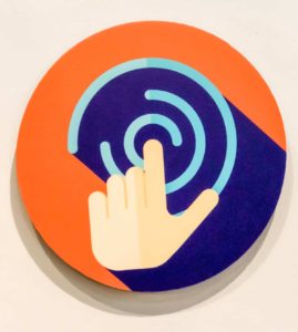 Sign indicating that it is an interactive exhibit. Hand with finger pointing.