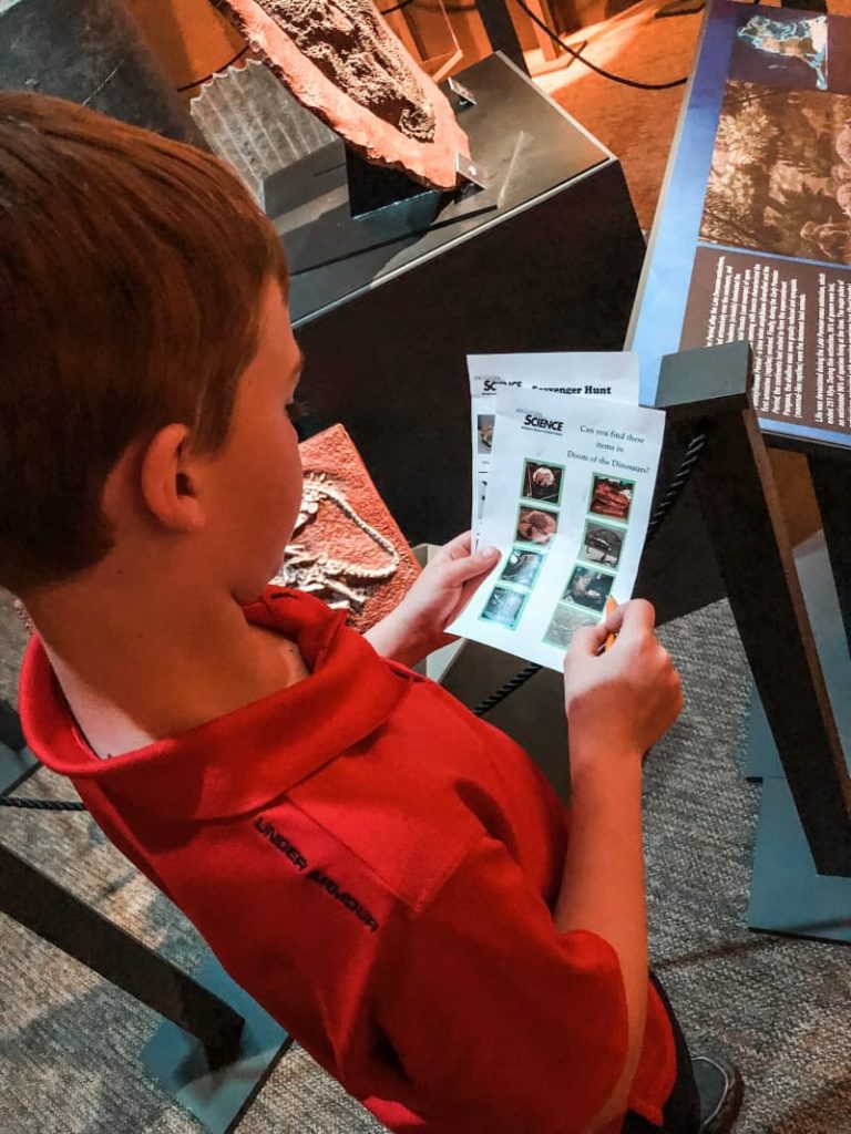 A boy looking at a scavenger hunt sheet at Cranbrook Institute of Science