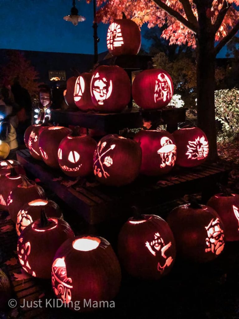 Pyramid of carved and lit pumpkins at night. 