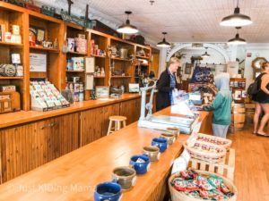 boy in an old fashion general store with a woman clerk at the cash register