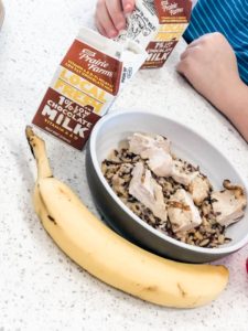 bowl of rice and chicken, banana and chocolate milk carton