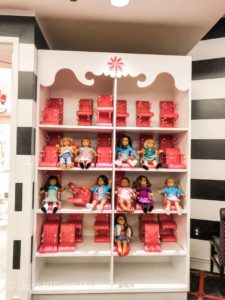 Shelf full of American Girl Dolls and High Chairs